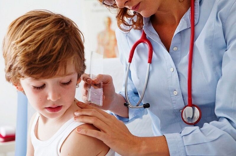 doctor examines a child with papilloma on the body